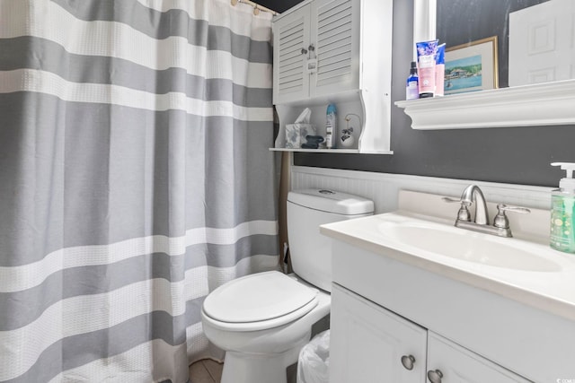 bathroom featuring curtained shower, toilet, vanity, and tile patterned flooring