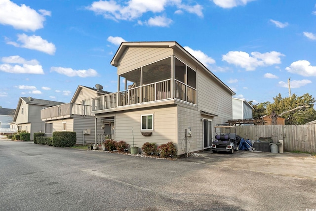 exterior space featuring a sunroom and fence