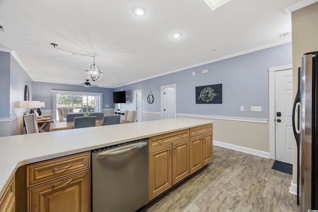 kitchen with light wood-style flooring, open floor plan, stainless steel appliances, crown molding, and light countertops