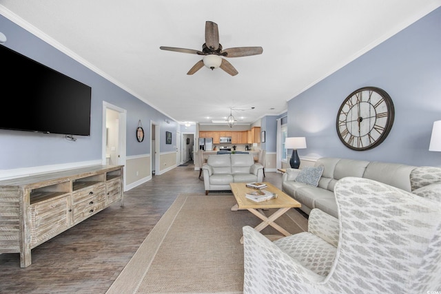 living area featuring dark wood finished floors, crown molding, a ceiling fan, and baseboards