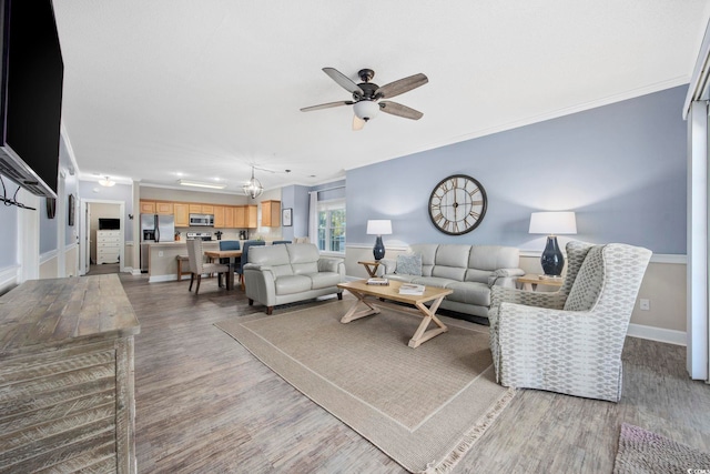 living area featuring crown molding, a ceiling fan, and light wood finished floors