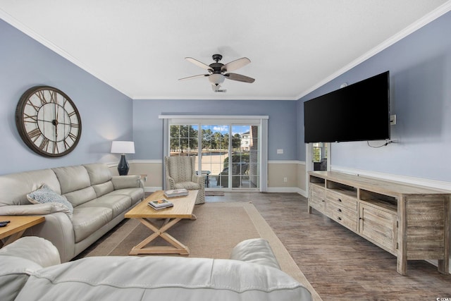 living room featuring ornamental molding, baseboards, a ceiling fan, and wood finished floors