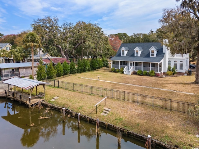 exterior space featuring a water view, a lawn, and a fenced backyard