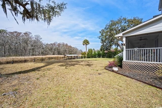 view of yard with ceiling fan and fence