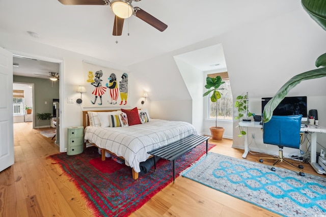 bedroom with lofted ceiling, wood finished floors, and a ceiling fan