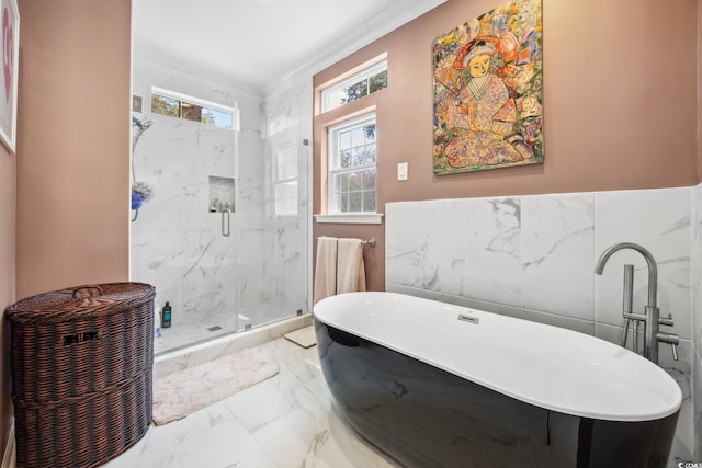 full bathroom with a marble finish shower, a freestanding bath, crown molding, tile walls, and marble finish floor