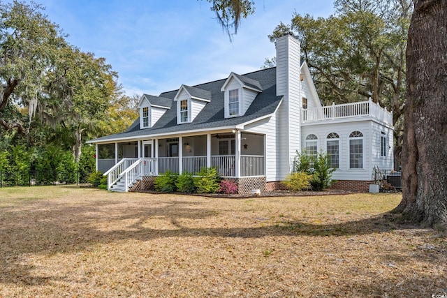 view of front of home featuring a front lawn, covered porch, and roof with shingles