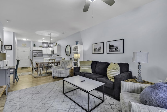 living area featuring light wood-style floors and a ceiling fan