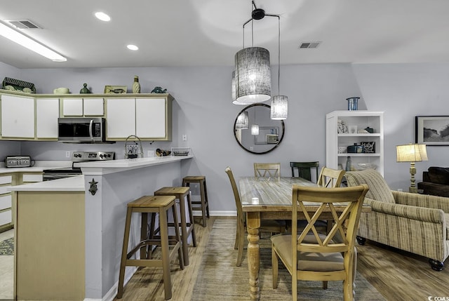 dining room featuring baseboards, recessed lighting, visible vents, and light wood-type flooring