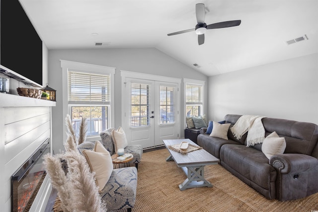 living area featuring a wealth of natural light, visible vents, french doors, and vaulted ceiling