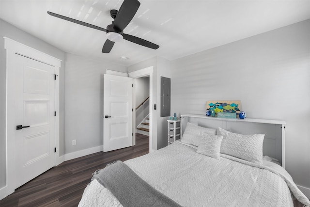 bedroom featuring electric panel, a ceiling fan, baseboards, and wood finished floors