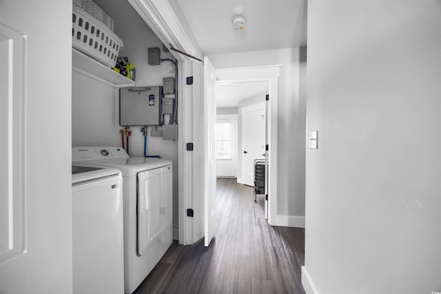 washroom with dark wood-style floors, baseboards, washing machine and dryer, and laundry area