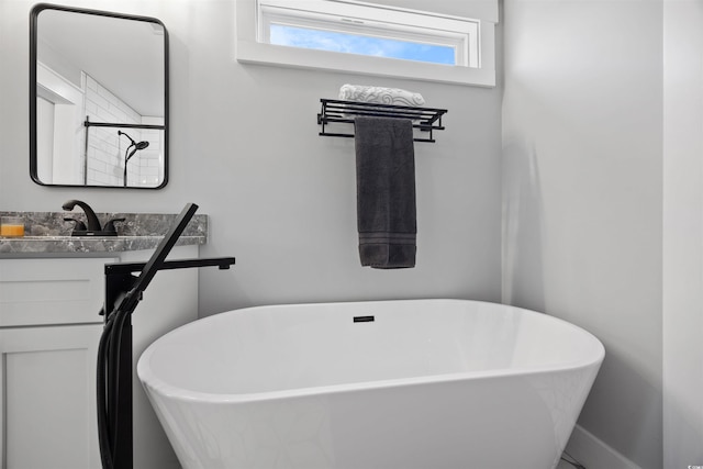 bathroom featuring a soaking tub and vanity