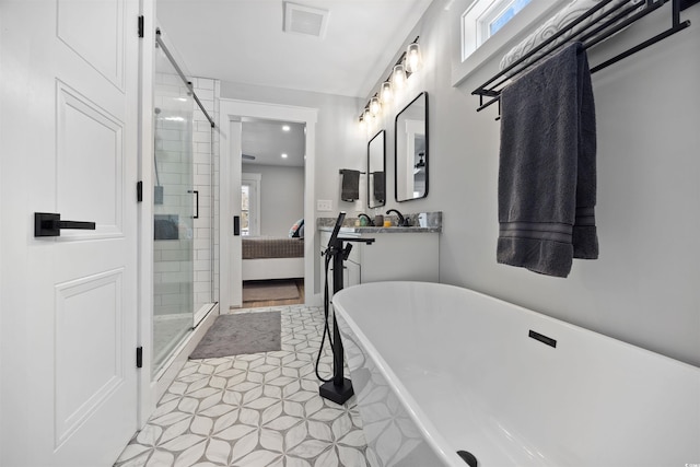 ensuite bathroom with visible vents, a shower stall, vanity, a freestanding tub, and ensuite bath