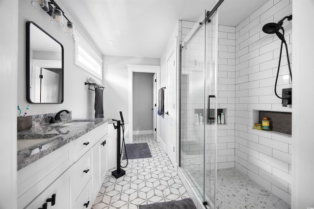 full bath with tile patterned flooring, a stall shower, and vanity