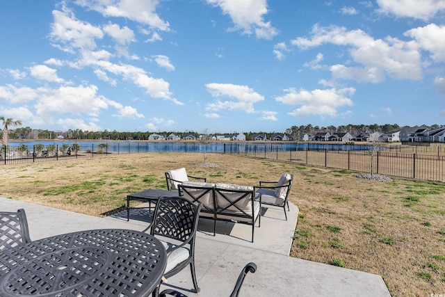 view of patio with a water view, a fenced backyard, and outdoor dining space