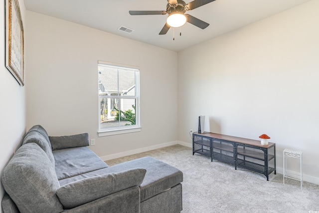 living area featuring a ceiling fan, light colored carpet, visible vents, and baseboards