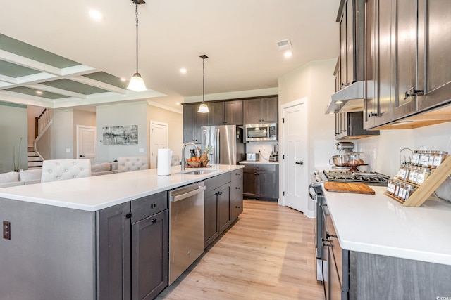 kitchen featuring under cabinet range hood, a sink, coffered ceiling, stainless steel appliances, and light wood-style floors