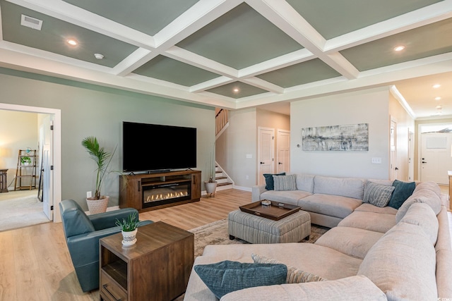 living area with light wood finished floors, visible vents, and coffered ceiling