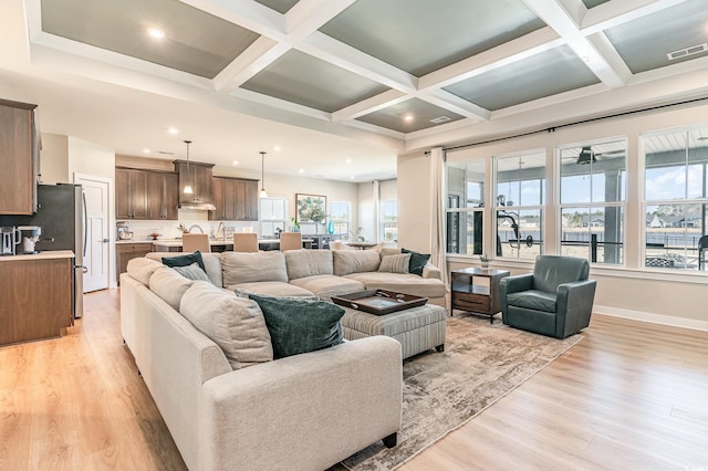 living room with visible vents, coffered ceiling, and light wood-style flooring