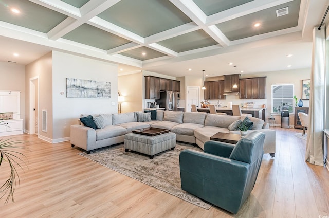 living room featuring beam ceiling, light wood-style floors, and coffered ceiling