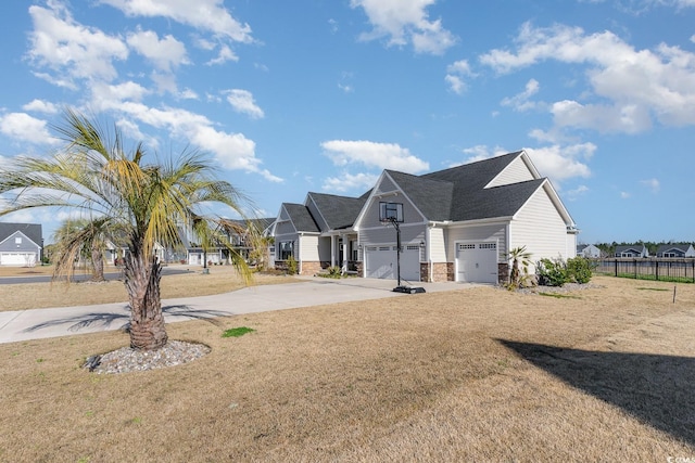 view of front of house featuring concrete driveway, fence, and a front lawn