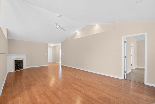 unfurnished living room with baseboards, light wood finished floors, ceiling fan, and vaulted ceiling