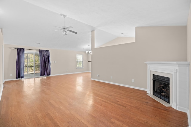 unfurnished living room with a fireplace with flush hearth, lofted ceiling, light wood-style floors, and ceiling fan