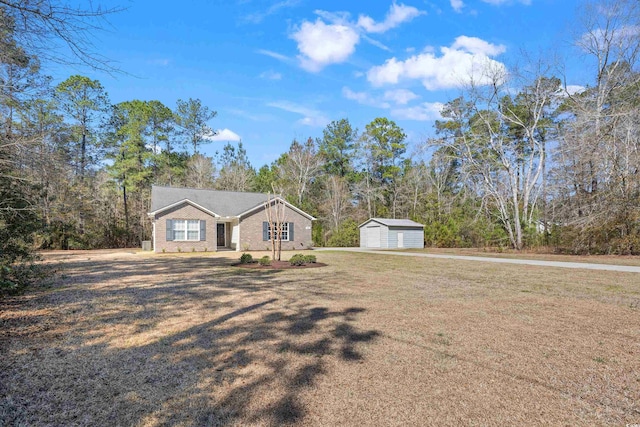 ranch-style home with a front lawn, a detached garage, and an outdoor structure