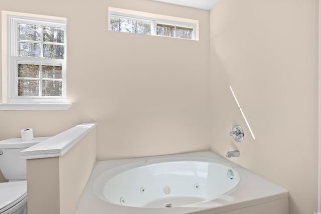 bathroom with toilet and a whirlpool tub