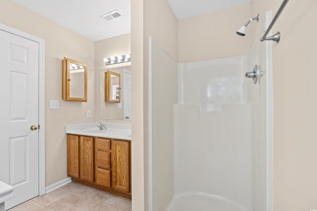 bathroom featuring tile patterned floors, visible vents, vanity, and walk in shower