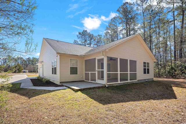 rear view of house featuring a lawn, roof with shingles, a ceiling fan, and a sunroom