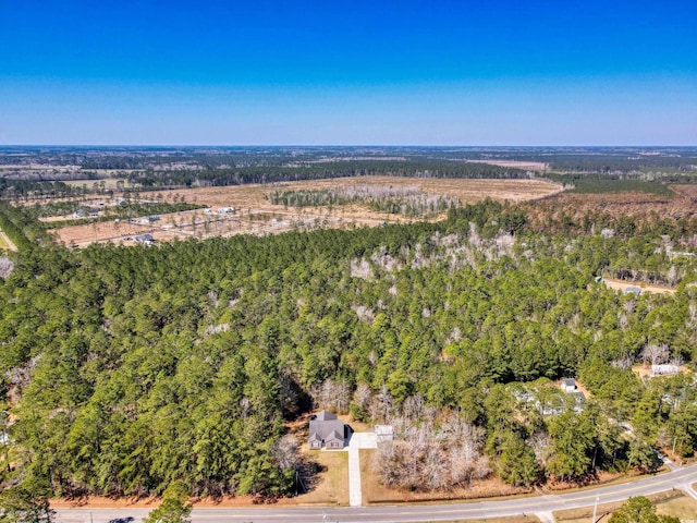 birds eye view of property featuring a view of trees