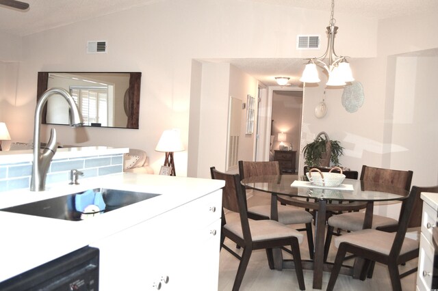 140 Spanish Oak Ct Unit 1, Surfside Beach, SC 29575 - dining space with vaulted ceiling, light wood-type flooring, and a chandelier