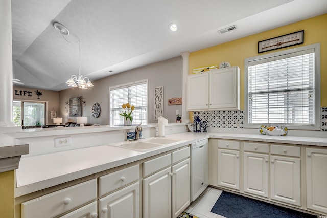 kitchen featuring visible vents, a healthy amount of sunlight, a chandelier, white dishwasher, and a sink