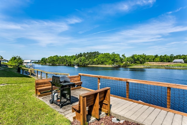 view of dock with a yard and a water view