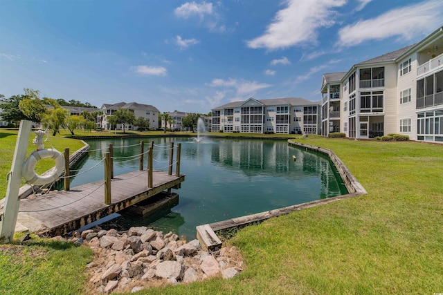 dock area with a residential view, a lawn, and a water view