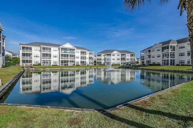 view of swimming pool featuring a lawn and a water view