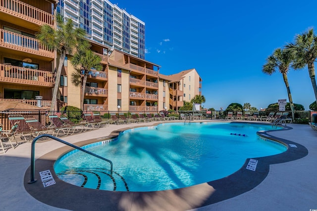 community pool featuring a patio and fence