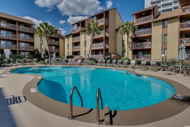 pool with a patio area and fence