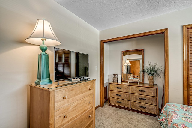 bedroom with light colored carpet and a textured ceiling