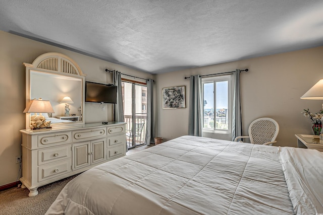 carpeted bedroom featuring access to exterior, a textured ceiling, and baseboards