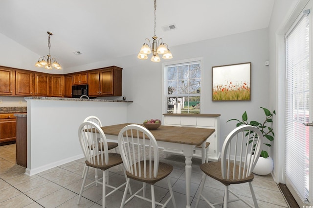 dining area featuring a chandelier, light tile patterned floors, visible vents, and lofted ceiling