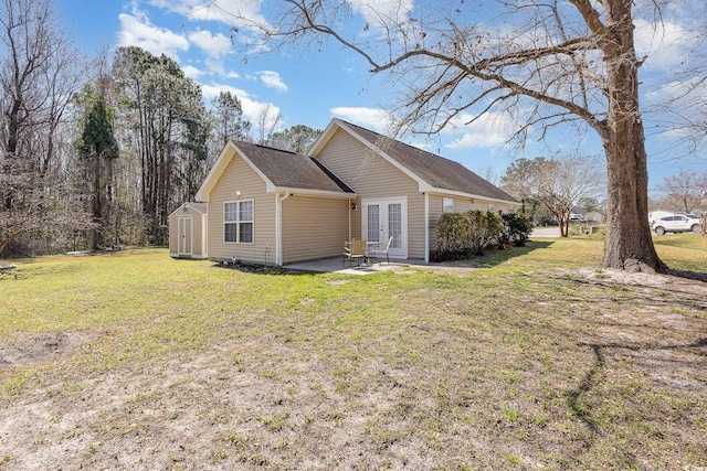 view of side of home with an outbuilding, a lawn, a shed, french doors, and a patio area