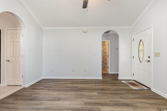 foyer with wood finished floors, ceiling fan, and crown molding