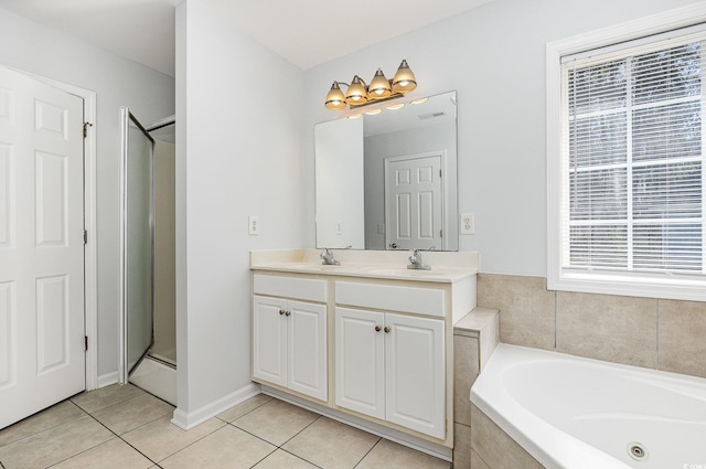 bathroom featuring visible vents, double vanity, a whirlpool tub, a sink, and tile patterned flooring