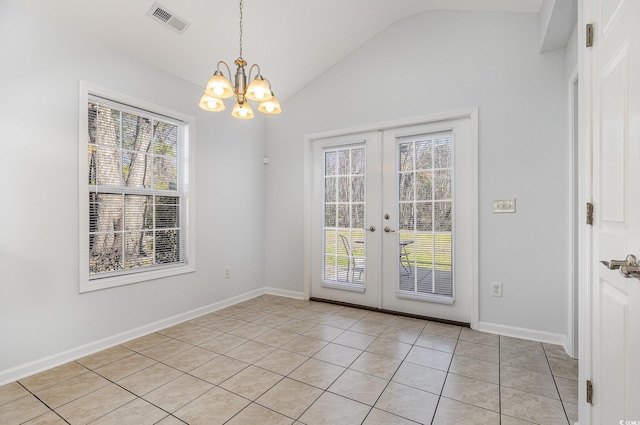 unfurnished dining area featuring visible vents, a notable chandelier, french doors, light tile patterned floors, and vaulted ceiling