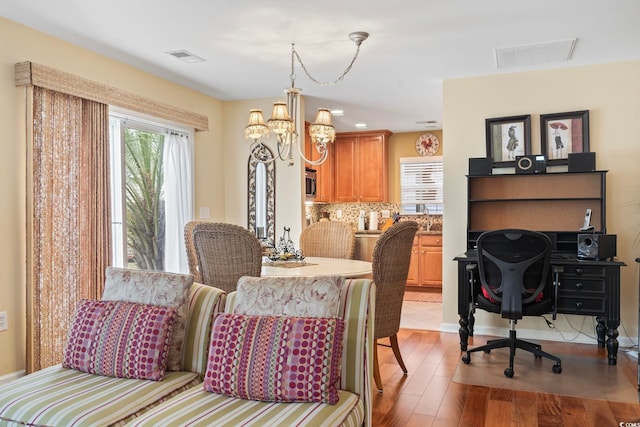 dining room featuring visible vents, wood finished floors, and a chandelier