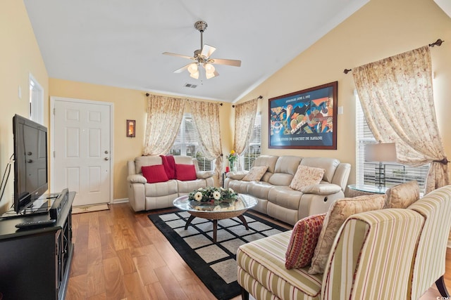 living area with light wood-style flooring, lofted ceiling, visible vents, and ceiling fan