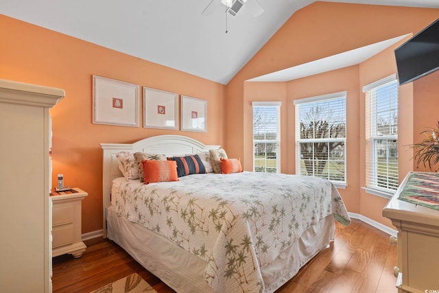 bedroom featuring a ceiling fan, vaulted ceiling, wood finished floors, and baseboards